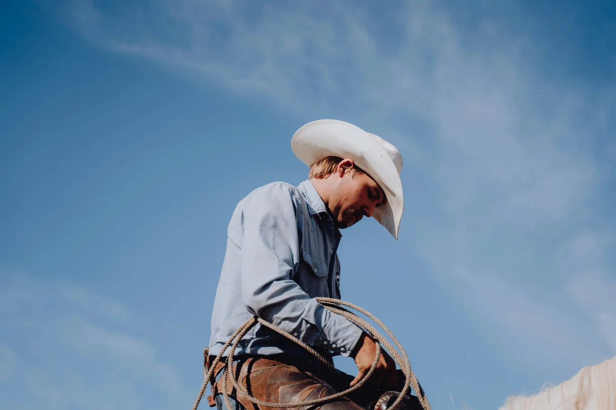 a man in a cowboy hat riding a horse - cowboy names for dogs