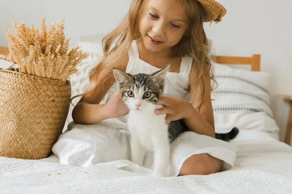 A young girl in a straw hat lovingly pets a kitten on a bed, creating a warm indoor atmosphere. - cute girl cat names