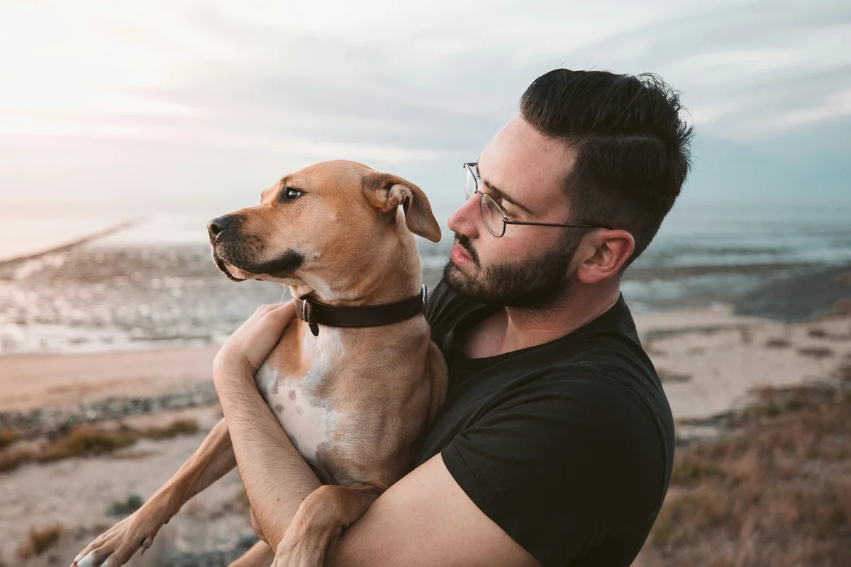 man holding a brown dog - human names for dogs
