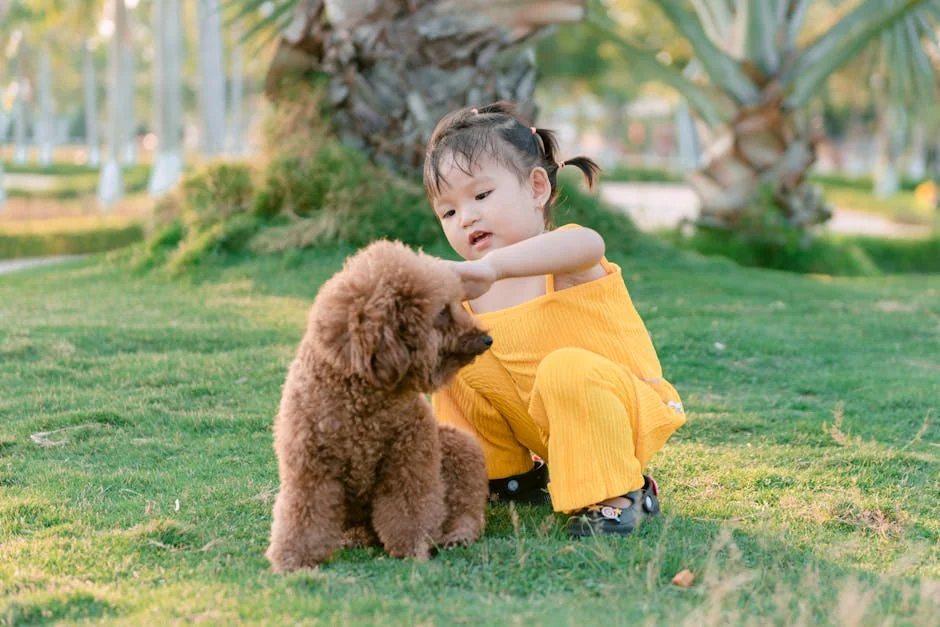 Young girl in a yellow outfit playing with her poodle dog in a sunny park setting. - nature inspired pet names for girls